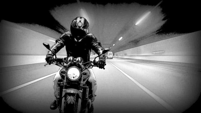 Une photo en noir et blanc d'une personne conduisant une moto.