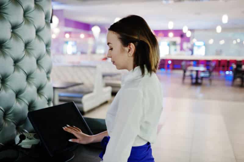 Une femme utilise un ordinateur portable dans un restaurant.