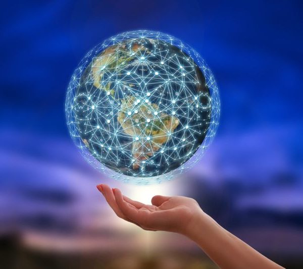 La main d'une femme tient un globe auquel est connecté un réseau.