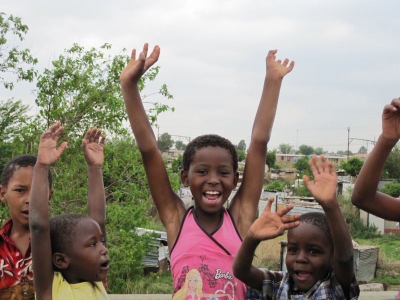 Un groupe d'enfants avec leurs mains levées en l'air.