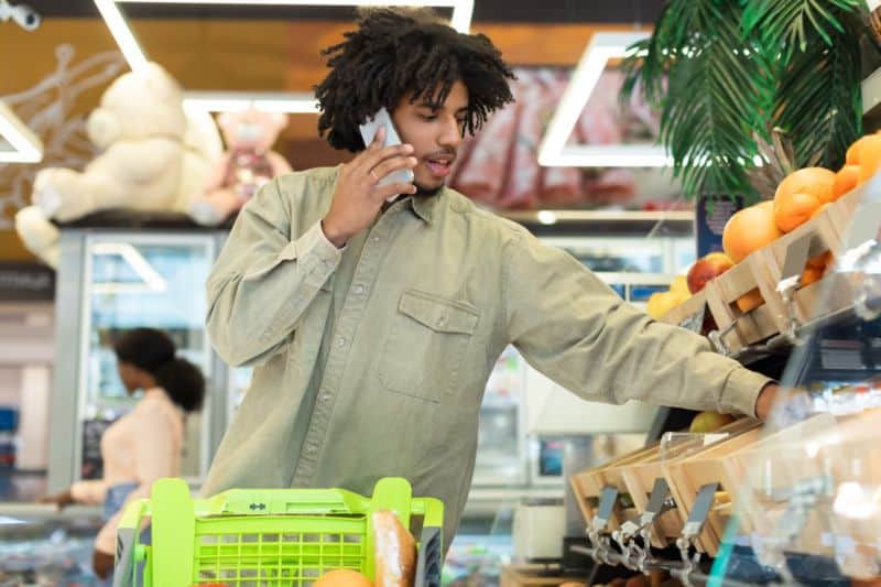 Un homme au téléphone portable dans une épicerie.