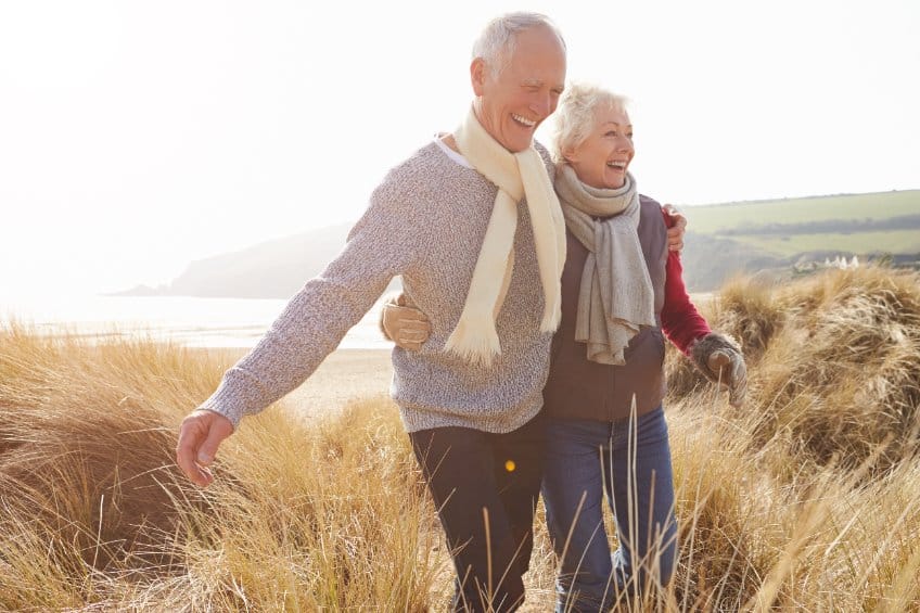 Un vieux couple marchant sur la plage.