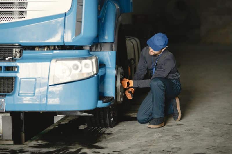 Un homme travaillant au volant d'un camion bleu.