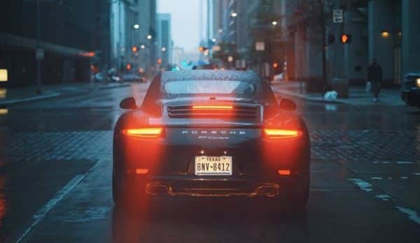 Une Porsche 911 roulant dans une rue de la ville la nuit.