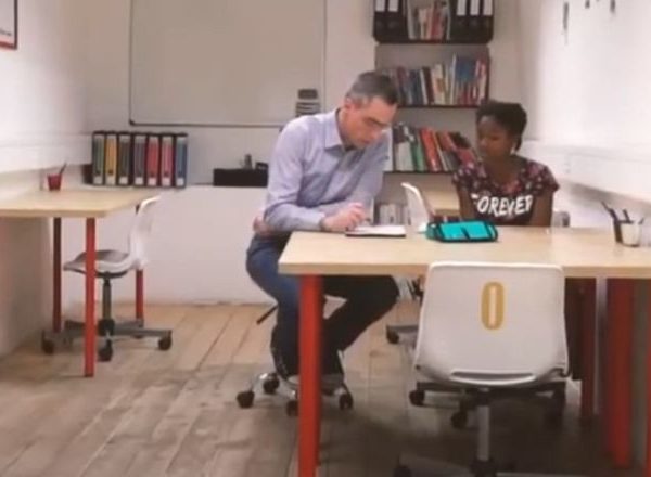 Un homme et une femme assis à un bureau dans une pièce.