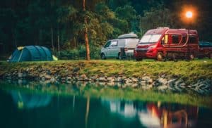 Deux Camping Cars Garés à Côté D'un Lac La Nuit.