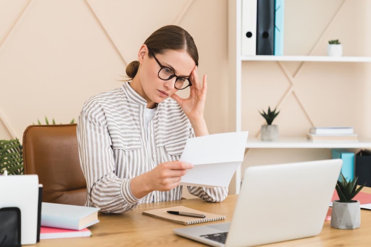 Une Femme Est Assise à Un Bureau Avec Une Lettre Devant Elle.