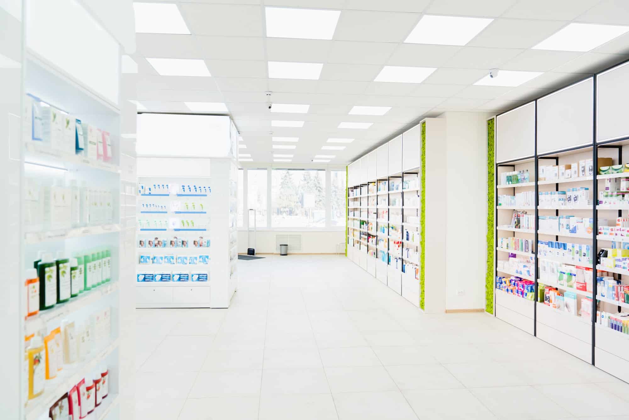 Spacious modern new white drugstore pharmacy chemist`s store with shelves full of medicines, pills