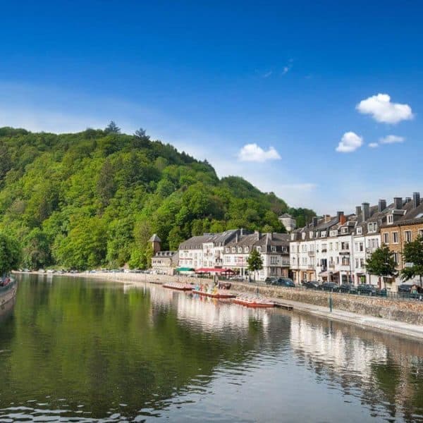 Une Rivière Entourée De Bâtiments Et D'arbres.