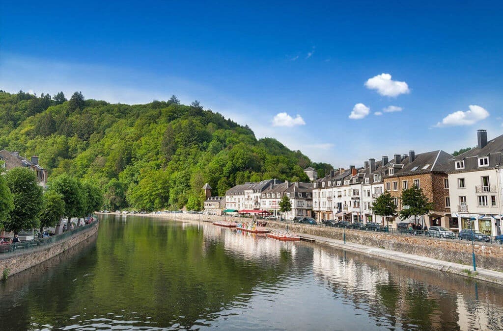 Une Rivière Entourée De Bâtiments Et D'arbres.