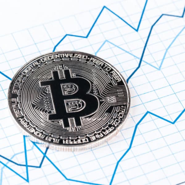 Un Bitcoin Se Trouve Au Sommet D’un Graphique.