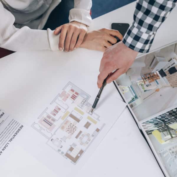 Un Groupe De Personnes Regardant Un Plan De Maison.