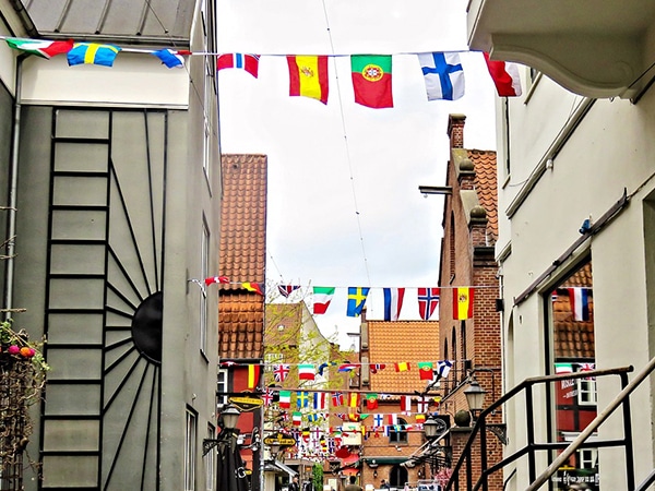 Une Rue Avec De Nombreux Drapeaux Accrochés Aux Immeubles.