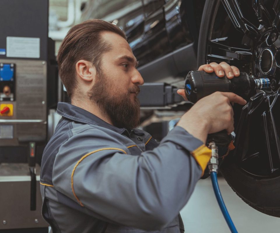 Un professionnel effectue un contrôle saisonnier des pneus d'une voiture.