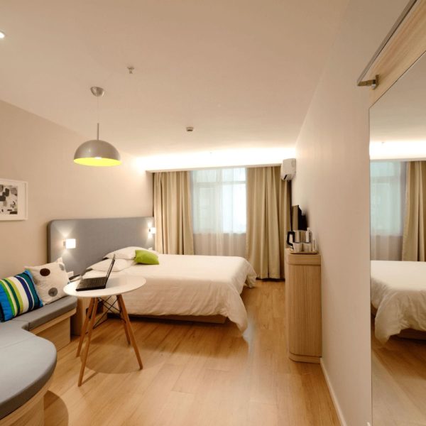 Une pièce meublée avec un lit et un bureau, conçu pour agrandir votre espace.
