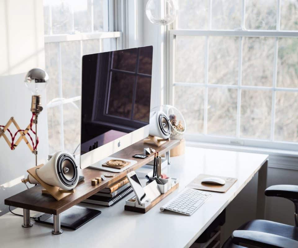 Un cadre bien équipé avec moniteur, clavier, souris et haut-parleurs pour le télétravail.