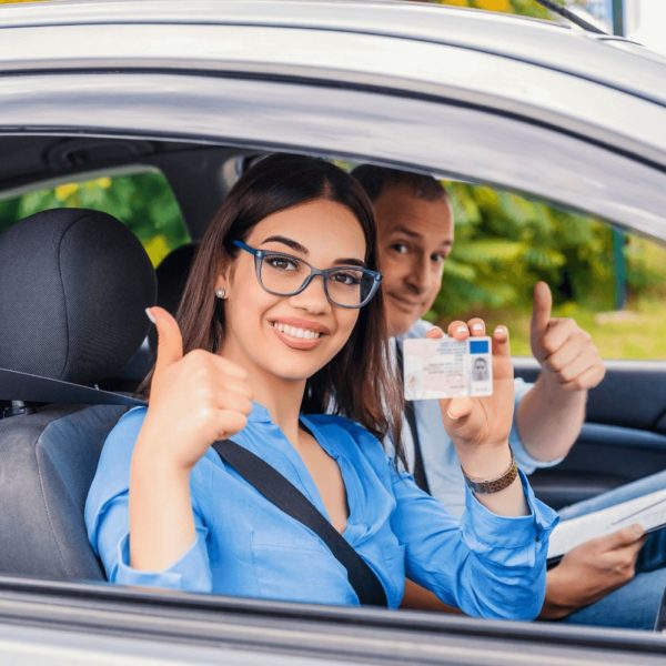 Une femme et un homme en voiture mettent en évidence leurs mains en signe de conduite autonome.