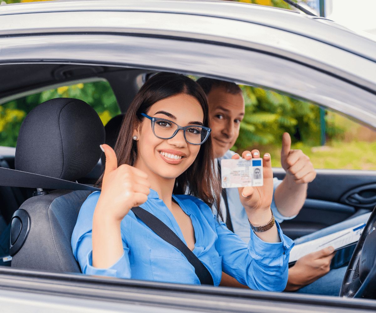 Une femme et un homme en voiture mettent en évidence leurs mains en signe de conduite autonome.