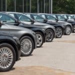 Une Rangée De Voitures Mercedes Benz Garées Devant Un Bâtiment.