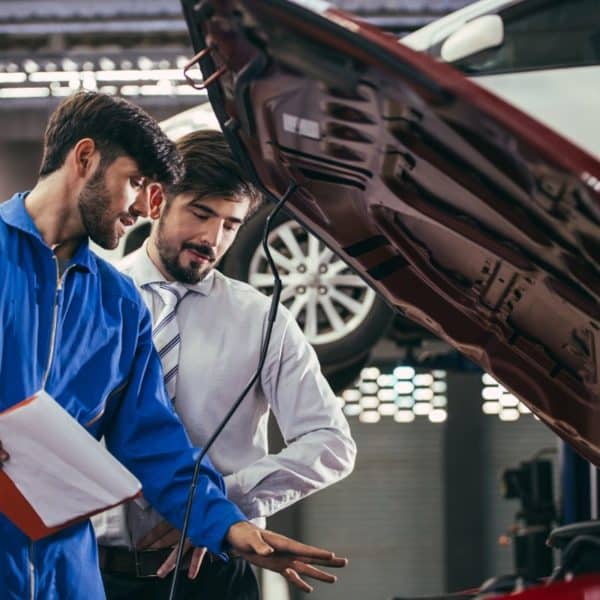Un mécanicien donne des conseils à son client pour l'entretien de sa voiture.