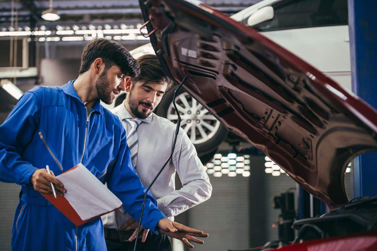 Un mécanicien donne des conseils à son client pour l'entretien de sa voiture.