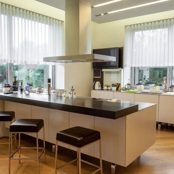 Une cuisine fonctionnelle moderne avec des tabourets et une fenêtre.