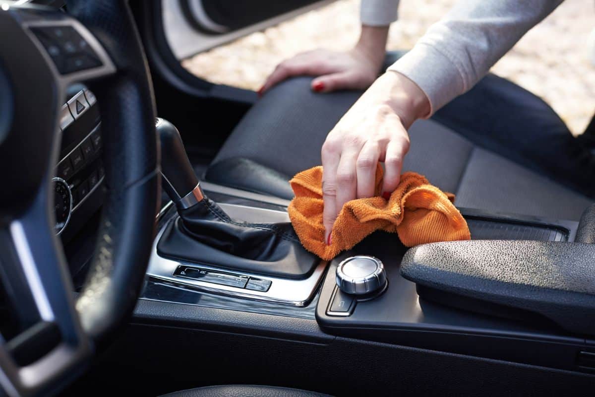 Une personne nettoie l'intérieur de sa voiture.