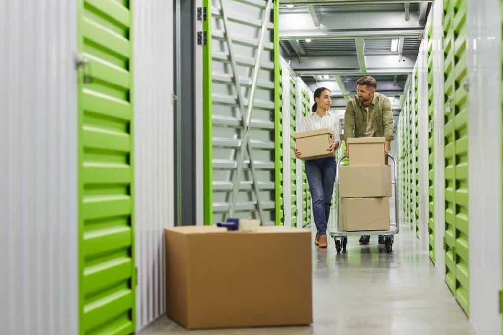 Un Homme Et Une Femme Déménagent Des Cartons Dans Une Unité De Stockage.