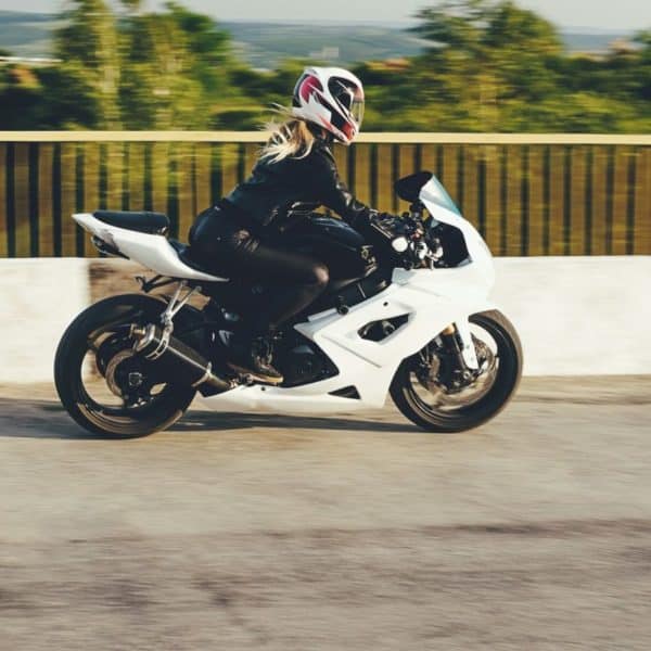 Une Femme Conduit Une Moto Blanche.