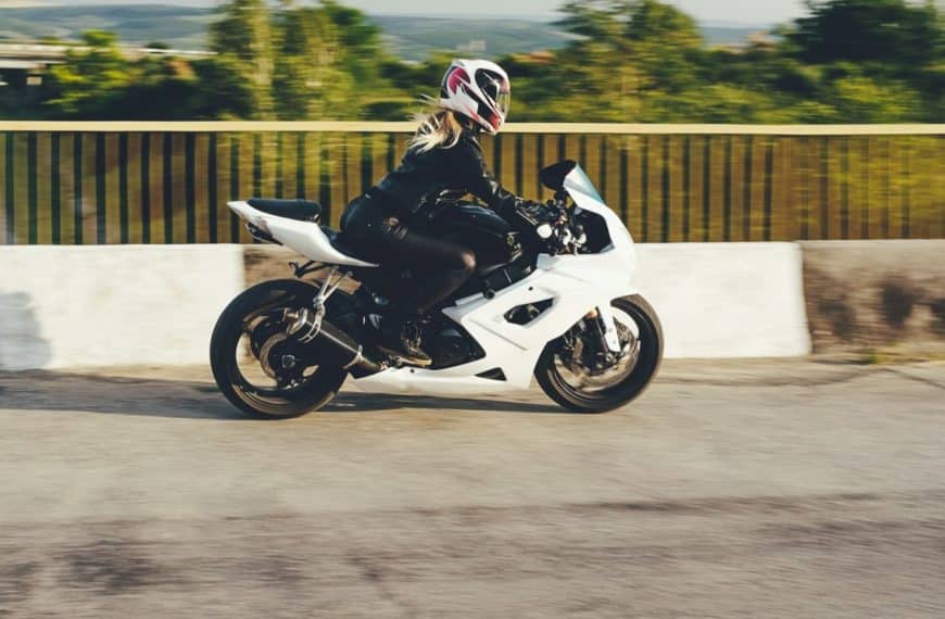 Une Femme Conduit Une Moto Blanche.