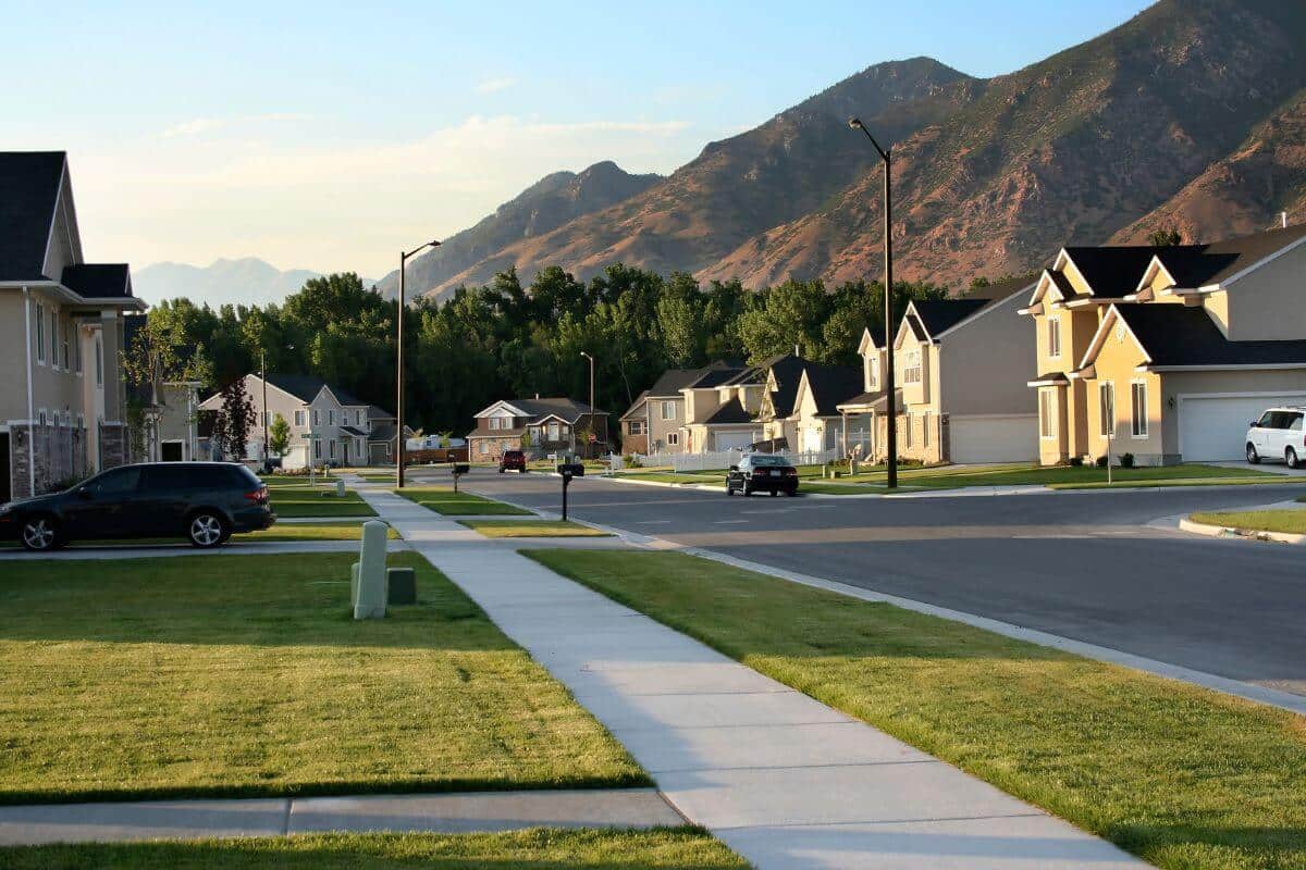 Un quartier avec des maisons et des montagnes en arrière-plan, offrant un potentiel de croissance et sécurisé.