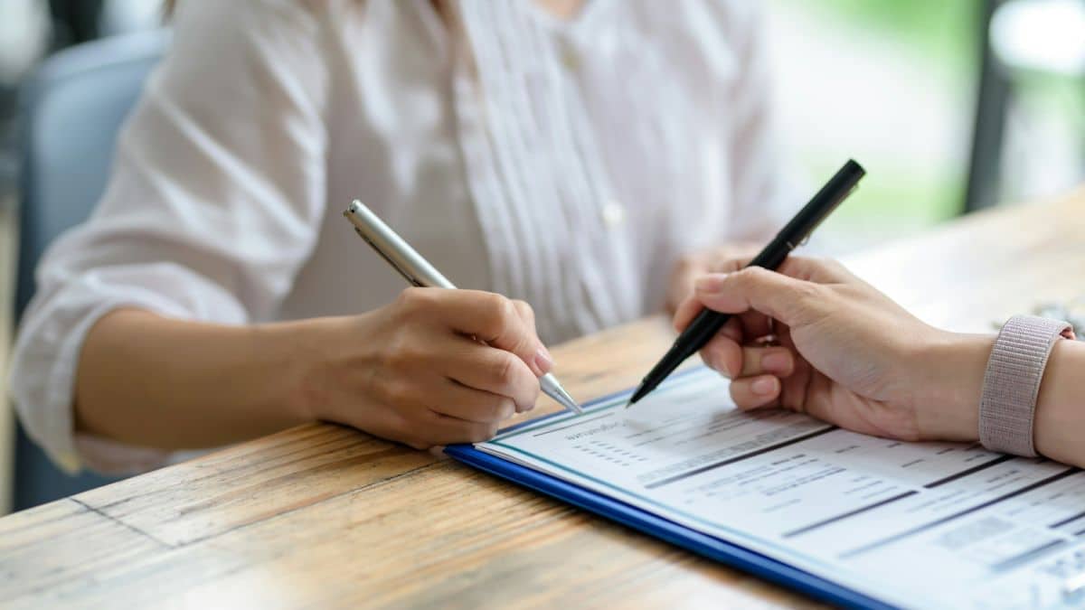 Business people sitting holding pen signing contract paper, lease mortgage.