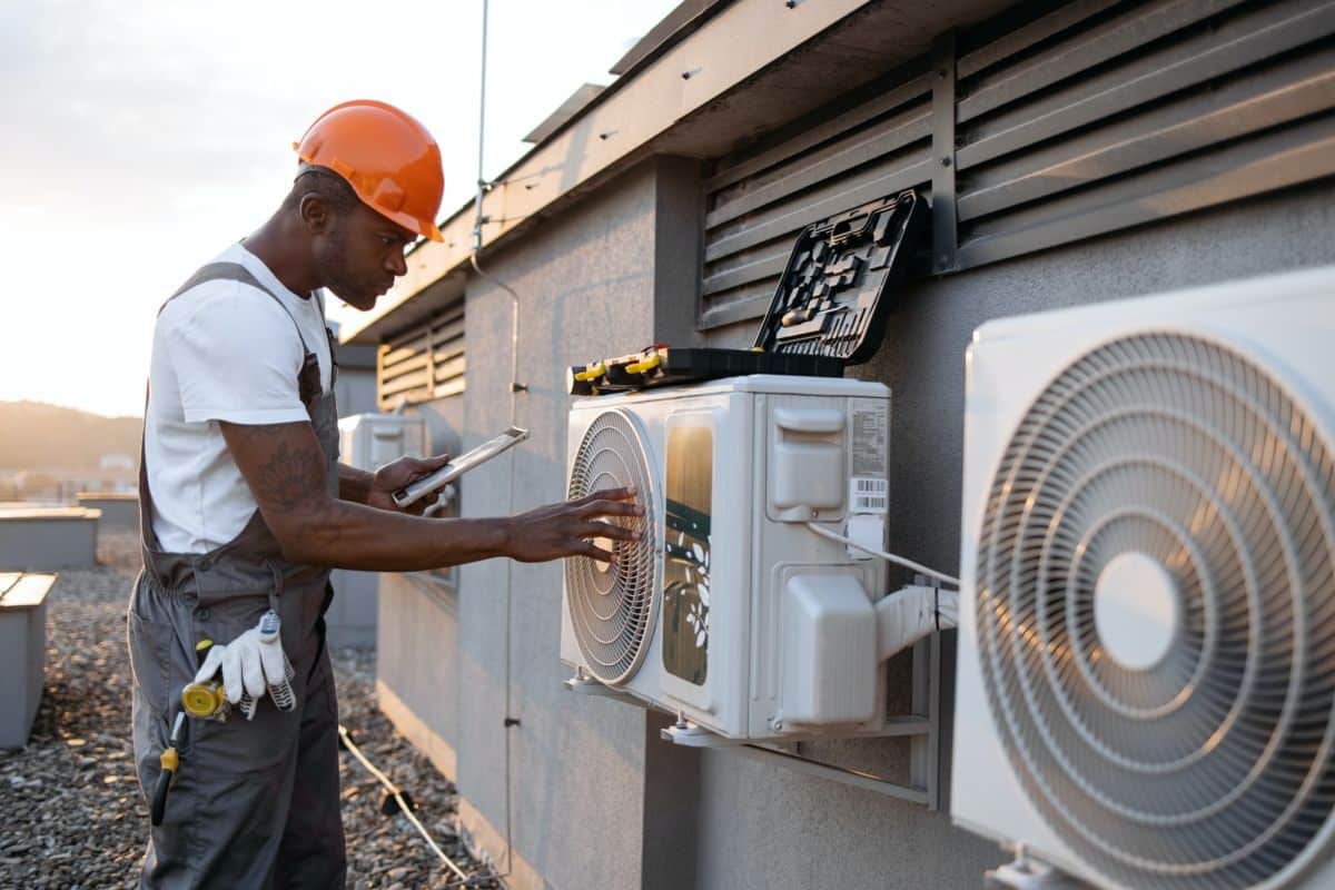 Un professionnel installe le système de climatisation d'une maison.