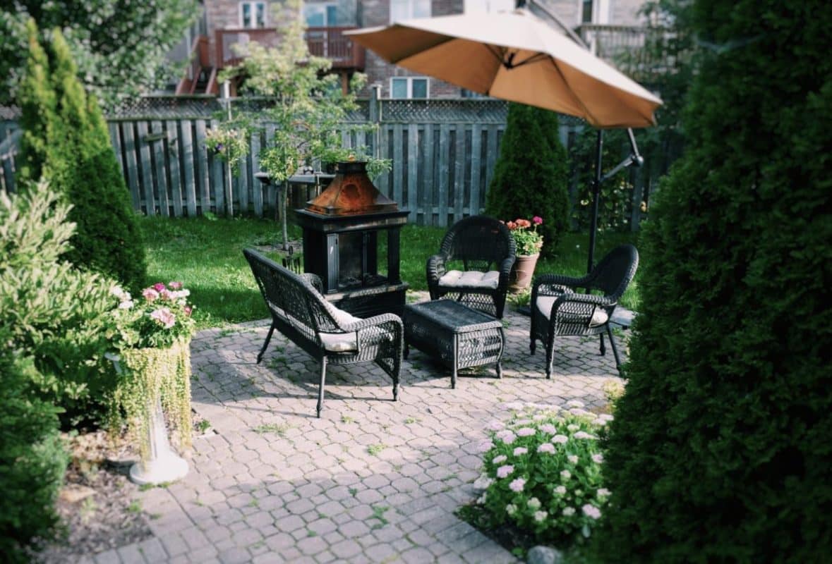 Un espace de vie extérieur entouré de verdure avec parasol. 