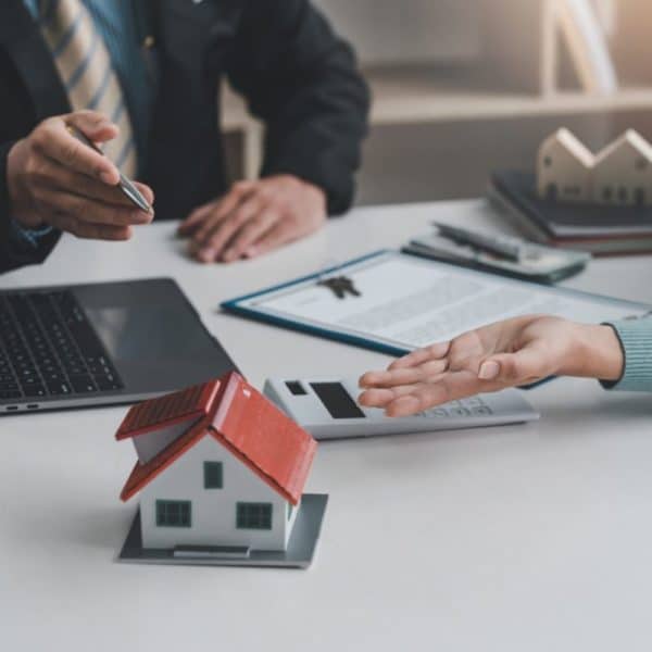 Real estate agents discuss the terms of the contract for the sale of the house at the office.