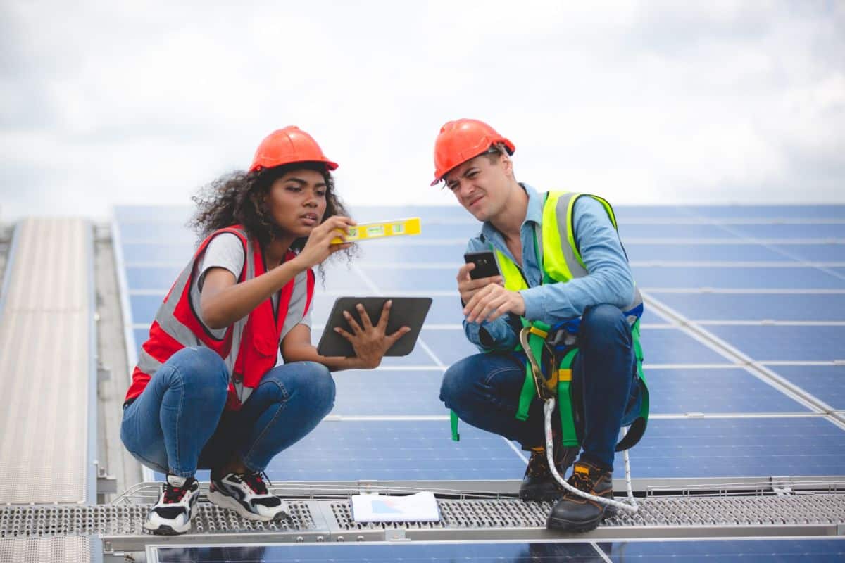 Deux Personnes Travaillant Sur Un Panneau Solaire.