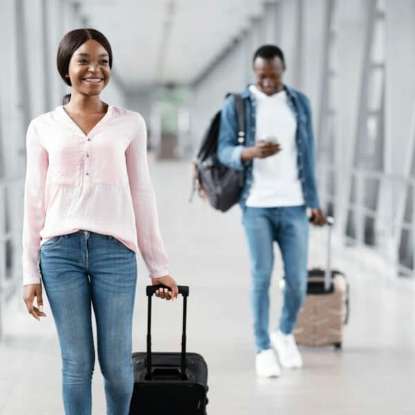 Une Femme Souriante Avec Des Bagages Dans Un Couloir.