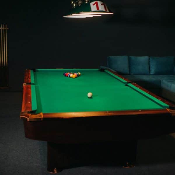 Table de billard avec surface verte et boules dans un club de billard.