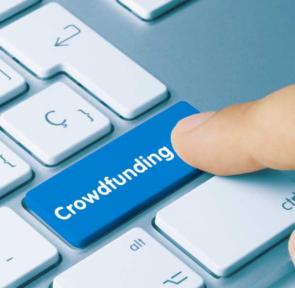 Un Doigt Appuie Sur Un Bouton Bleu « Crowdfunding » Sur Un Clavier D'ordinateur.