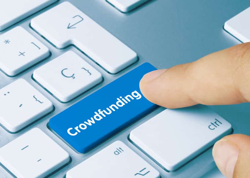 Un Doigt Appuie Sur Un Bouton Bleu « Crowdfunding » Sur Un Clavier D'ordinateur.