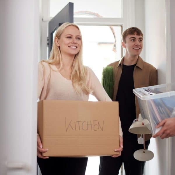 Group Of College Student Carrying Boxes Moving Into Accommodation Together
