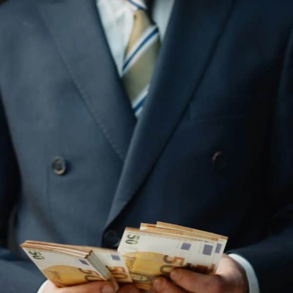 Une Personne En Costume Tient Une Pile De Billets De 50 Euros.