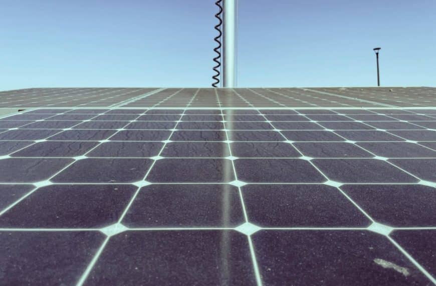 Gros Plan D'un Panneau Solaire Avec Un Ciel Bleu Clair En Arrière Plan. Un Poteau Métallique Avec Un Fil En Spirale Est Visible Au Loin.