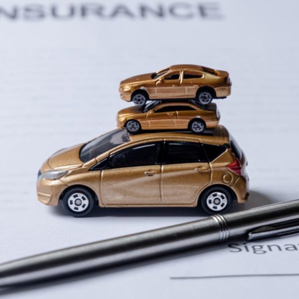 Car and pen on insurance documents. Car insurance concept.