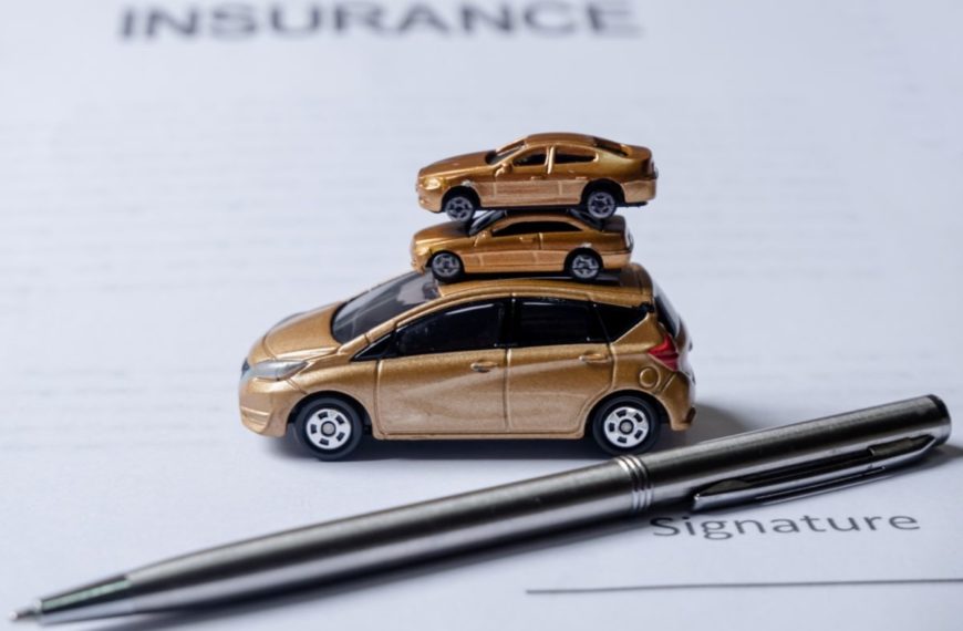 Car and pen on insurance documents. Car insurance concept.