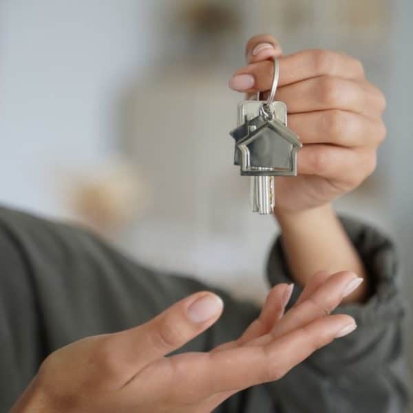 Female real estate agent tenant or homeowner holds keys of new house. Rental property, mortgage