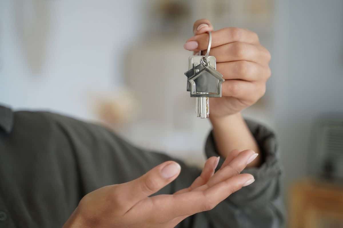 Female real estate agent tenant or homeowner holds keys of new house. Rental property, mortgage
