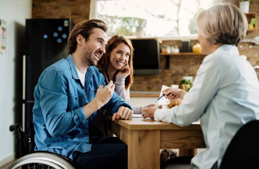 Young happy couple talking to insurance agent while using touchpad on a meeting.