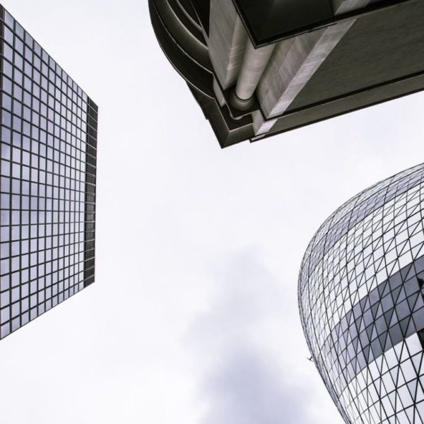 Vue Vers Le Haut De Trois Gratte Ciel Modernes Avec Des Façades En Verre Contre Un Ciel Nuageux.