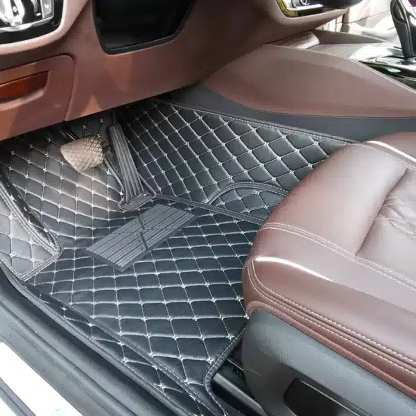 L'image Montre La Zone Passager Avant D'un Intérieur De Voiture Avec Des Tapis De Sol Matelassés Foncés Et Des Sièges En Cuir Marron.